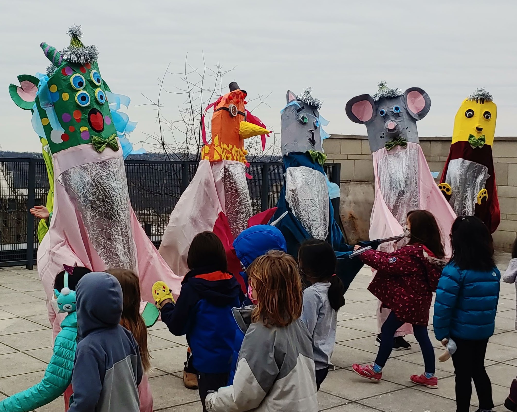 Giant puppets interact with little kids