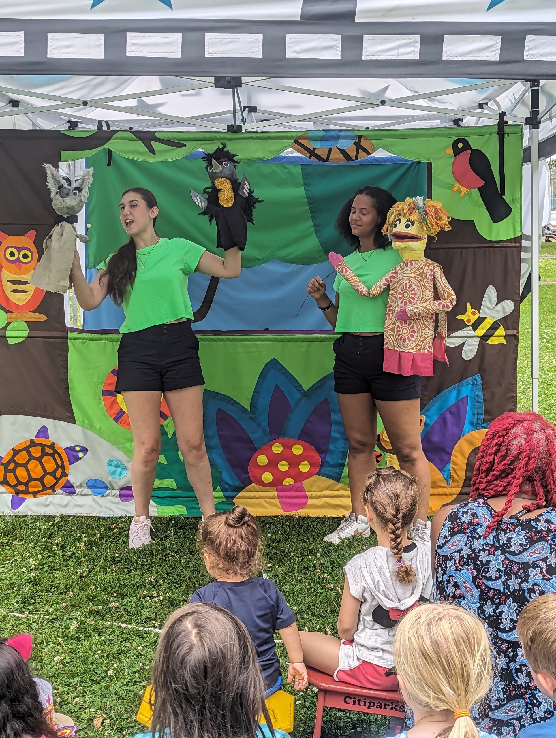 Two people performing a puppet show outdoors